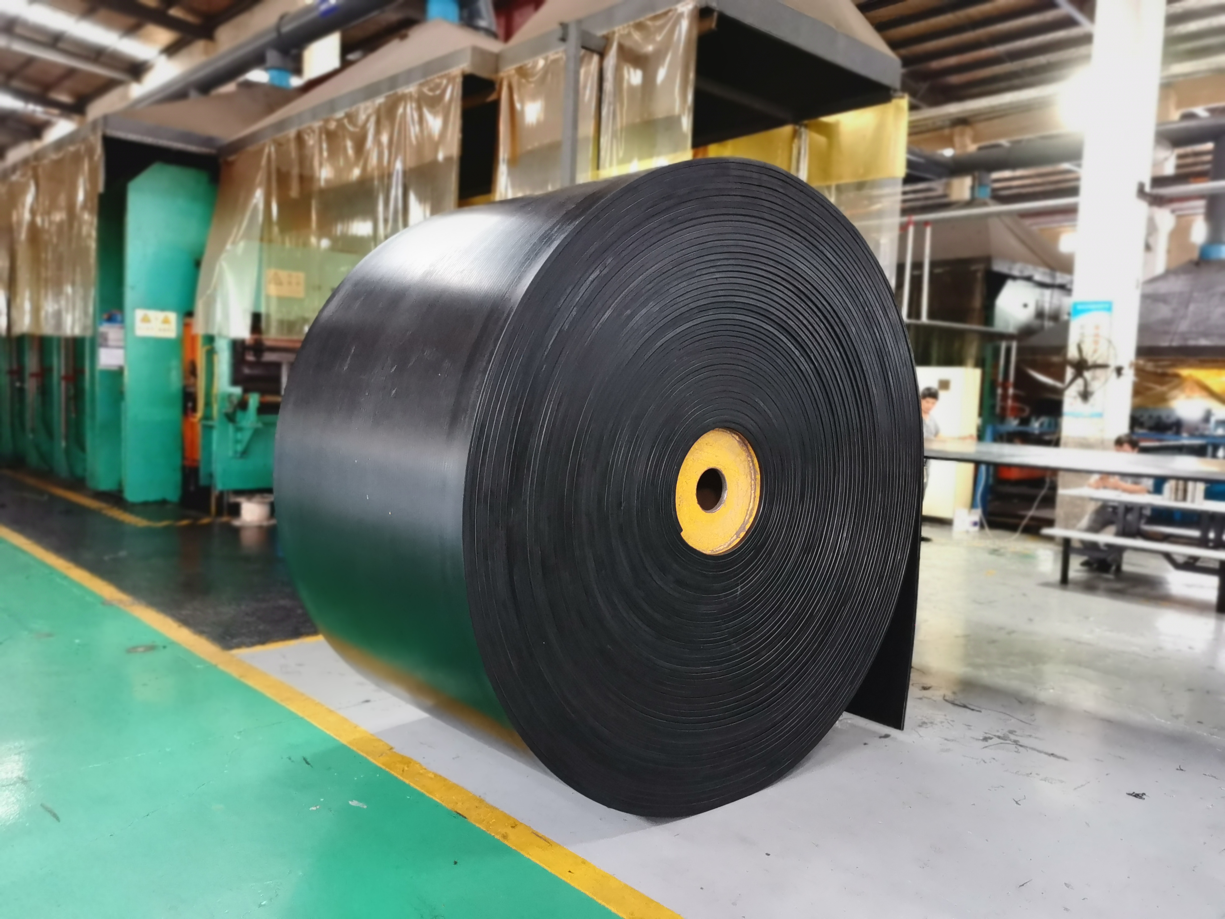 Rubber conveyor belt roll inside an industrial conveyor belt manufacturing workshop