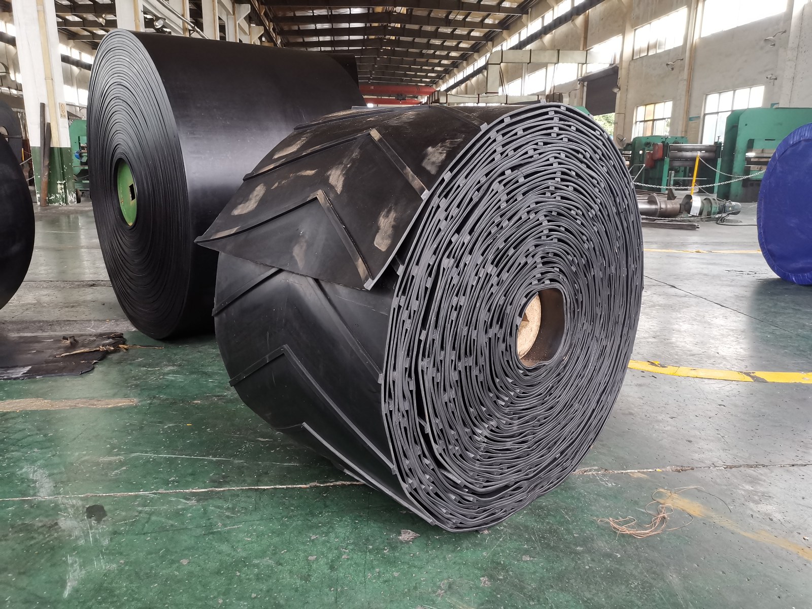 Chevron conveyor belt roll with V-shaped cleats