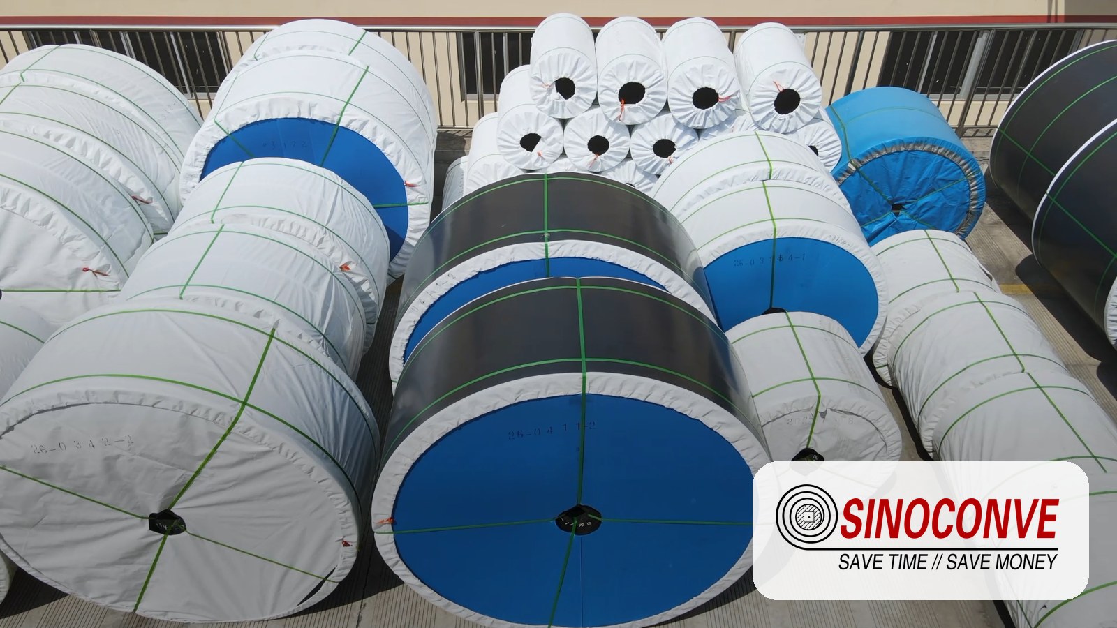 Finished EP conveyor belt roll in a factory inspection bay with thickness gauge and ply test sample on the bench
