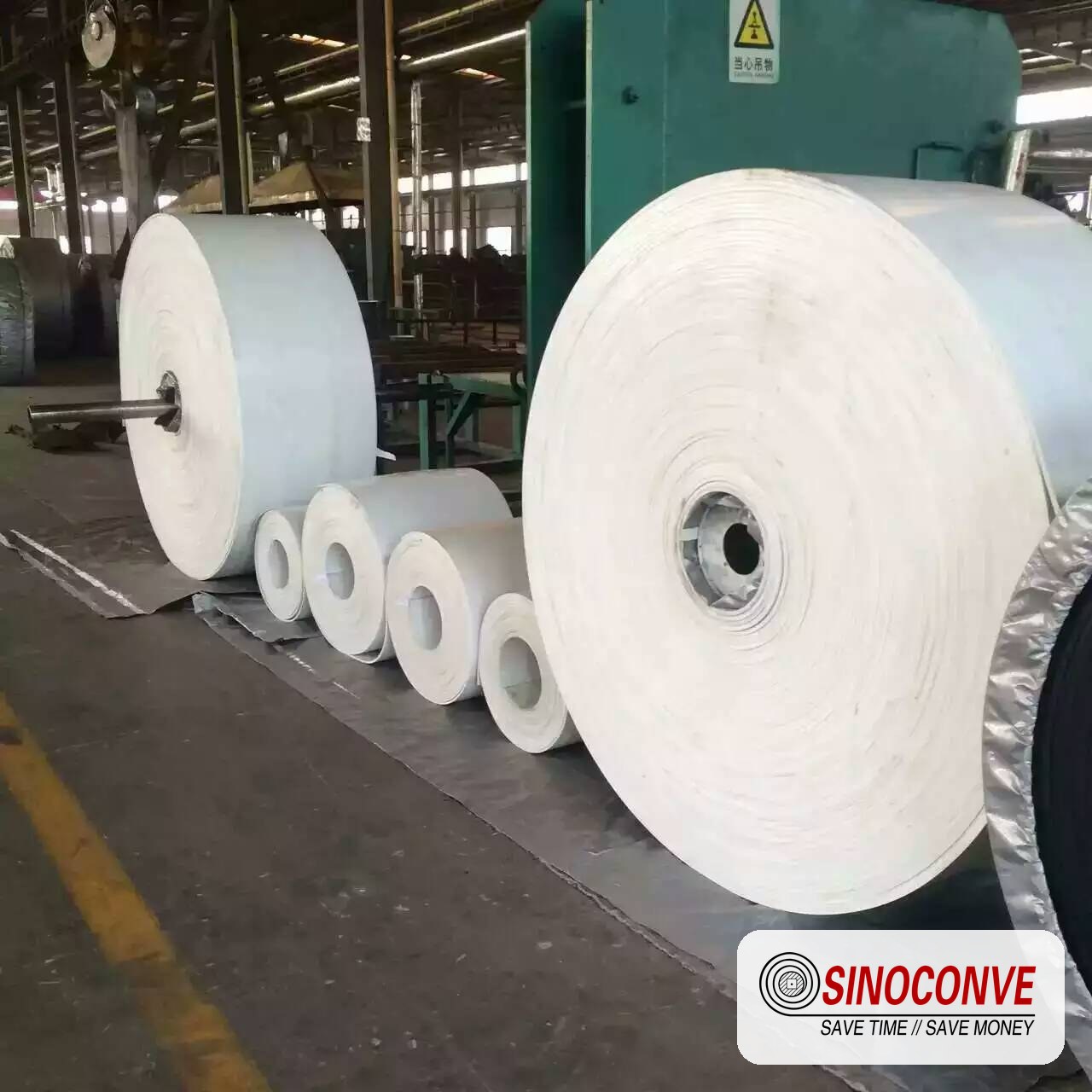conveyor belt rolls stored on a factory floor