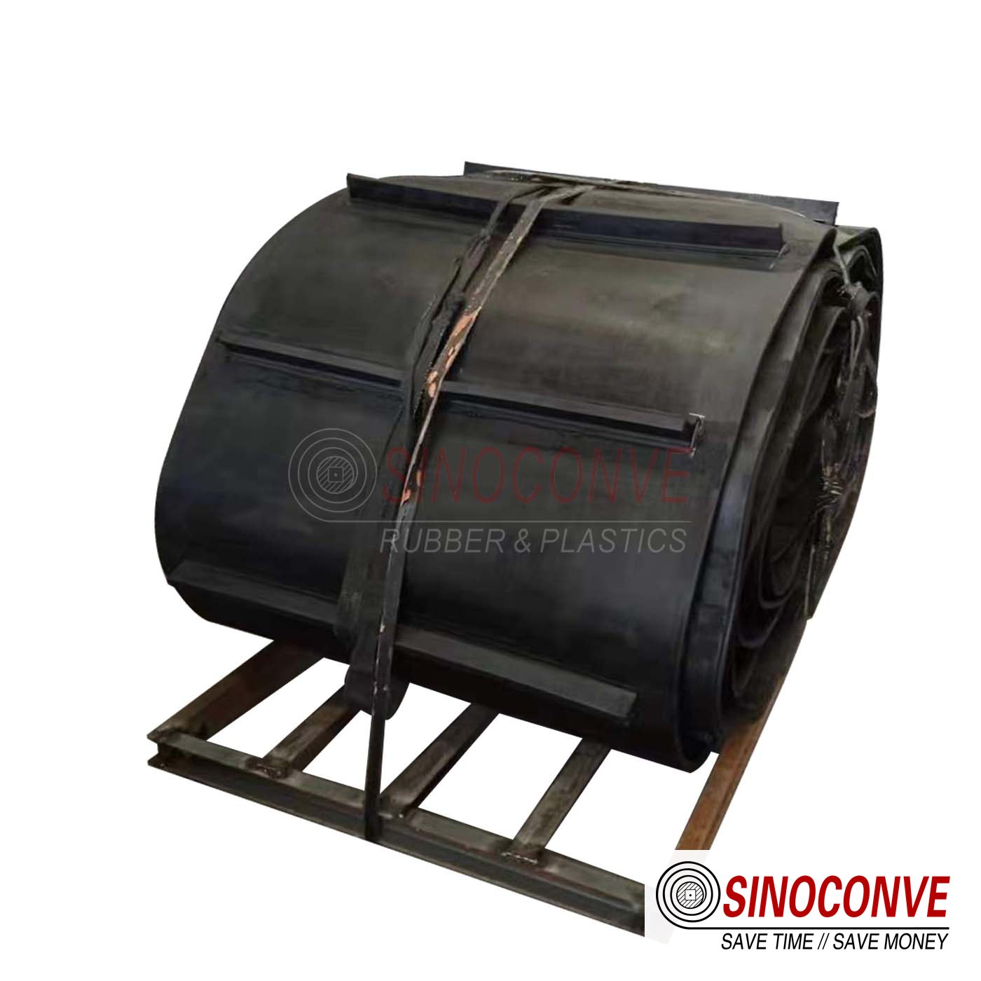 Rolls of black rubber conveyor belt with lateral ribs, wrapped and strapped on a wooden pallet for shipment to a biomass fuel plant