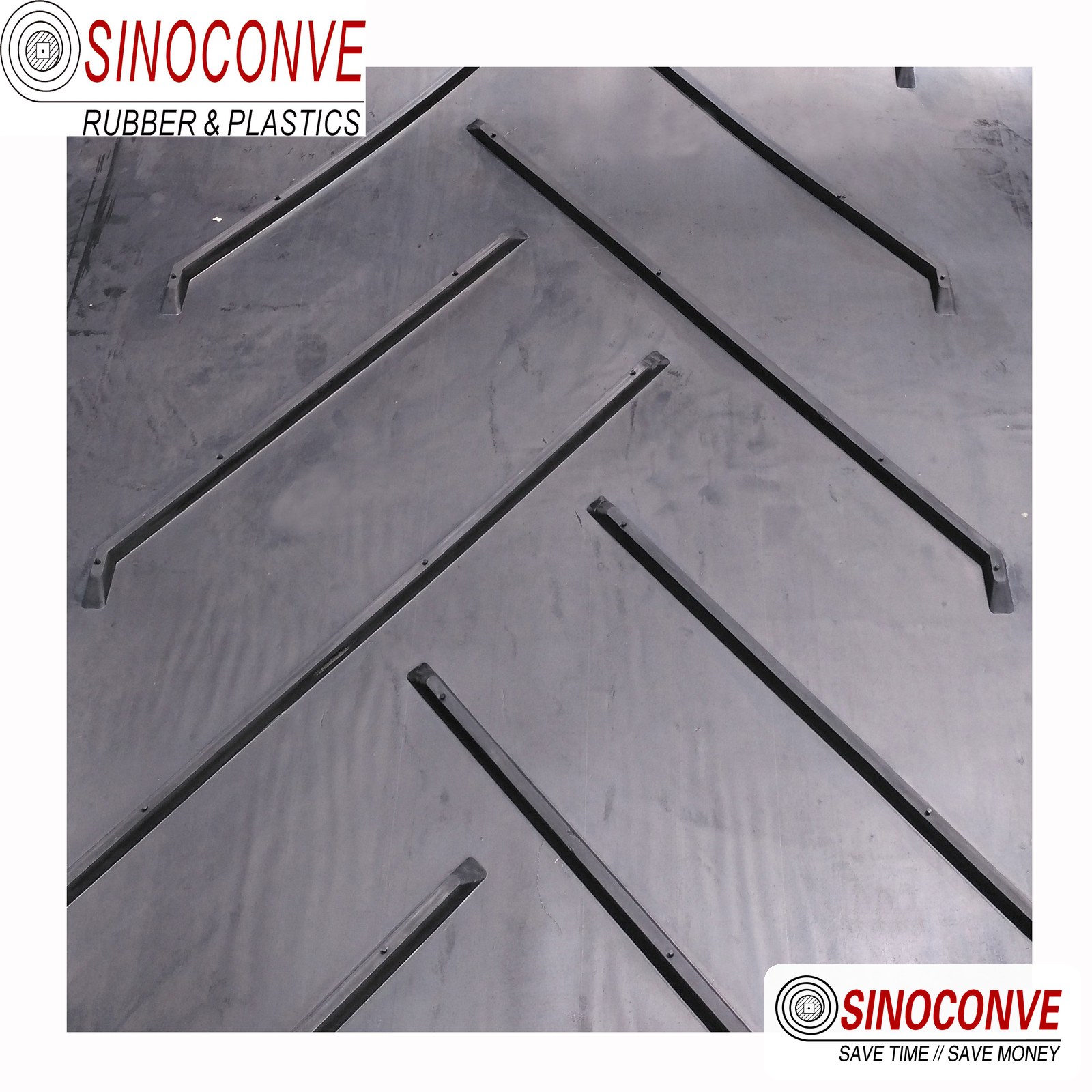 Close-up of a black chevron conveyor belt showing the raised V-shaped ribs used on a biomass silo incline