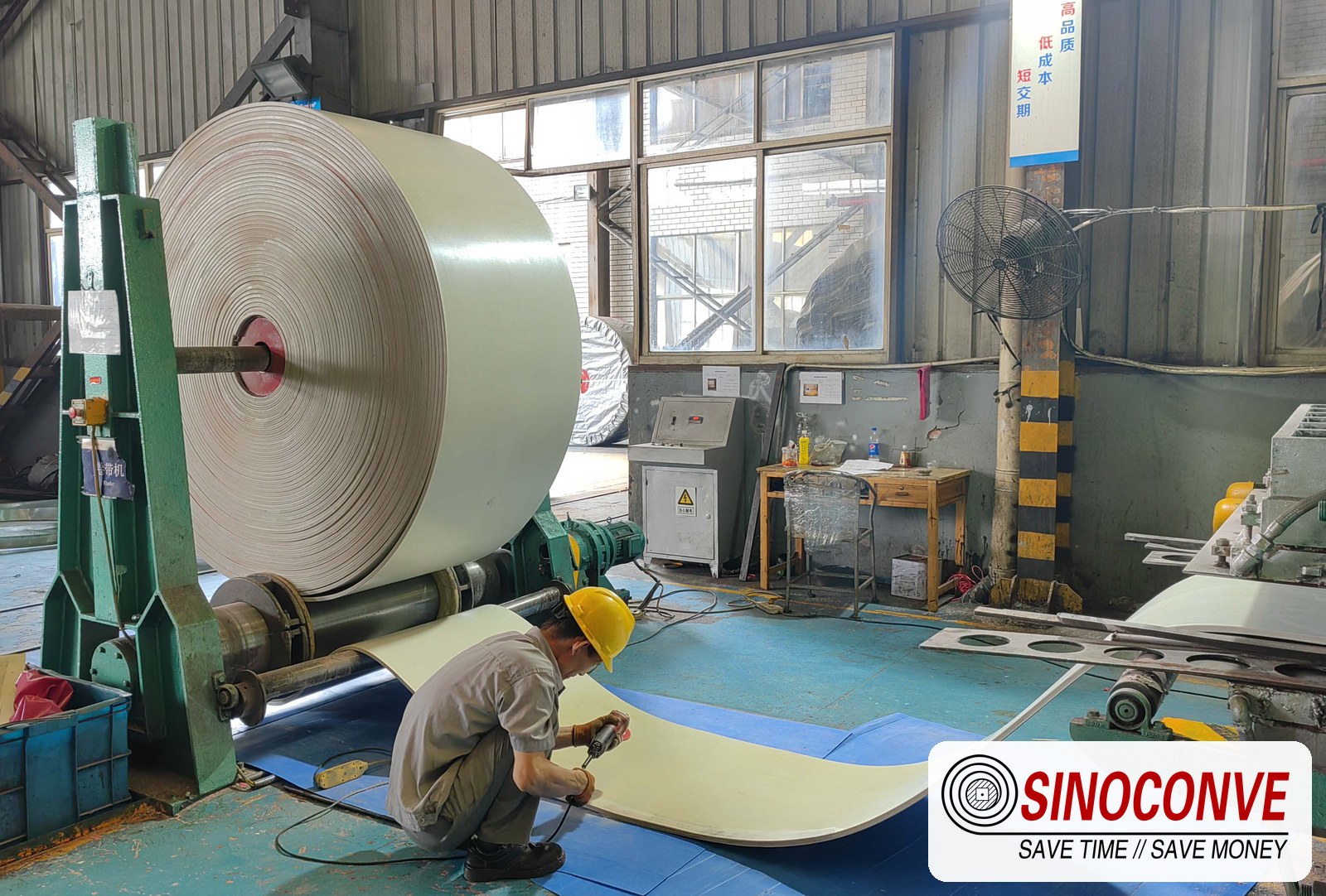 Cream food-grade belt being slit on the line for a grain elevator conveyor belt