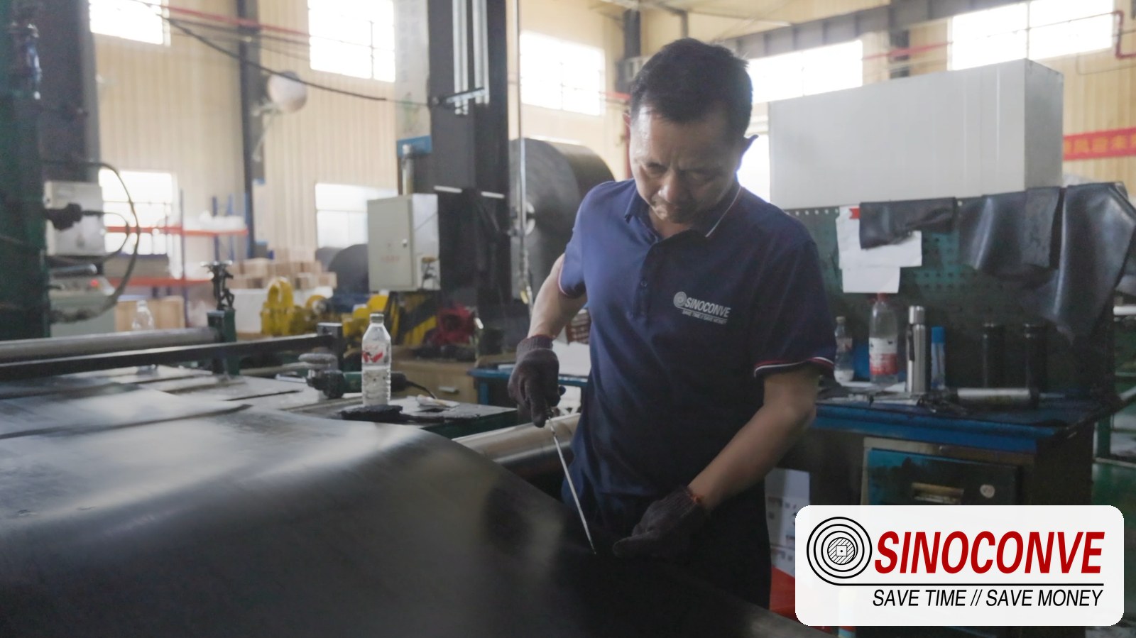 Technician checking a belt surface at the plant that builds bauxite conveyor belts